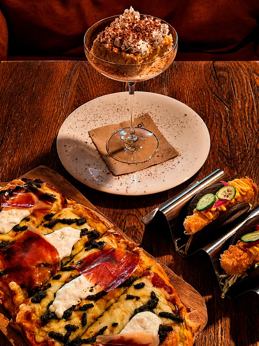 Pizza y postre servidos en la mesa de Nômadâ