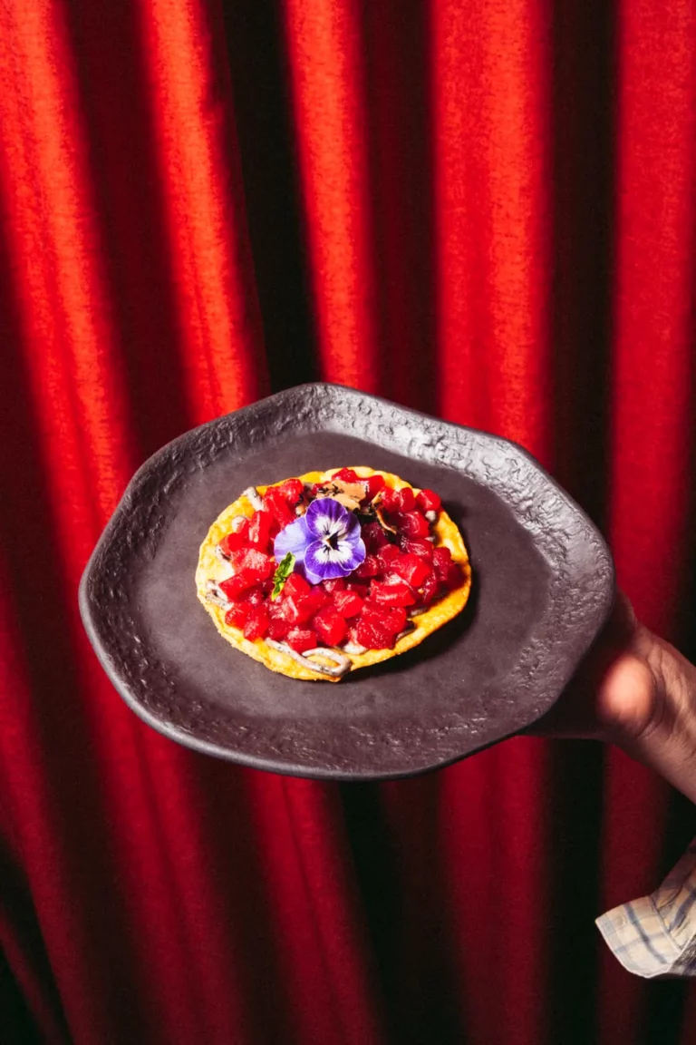 Toast with tomato and edible flowers from the menu at Nômadâ, Madrid